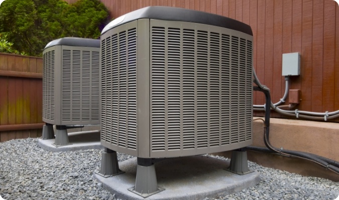 2 air conditioning units outside of a house